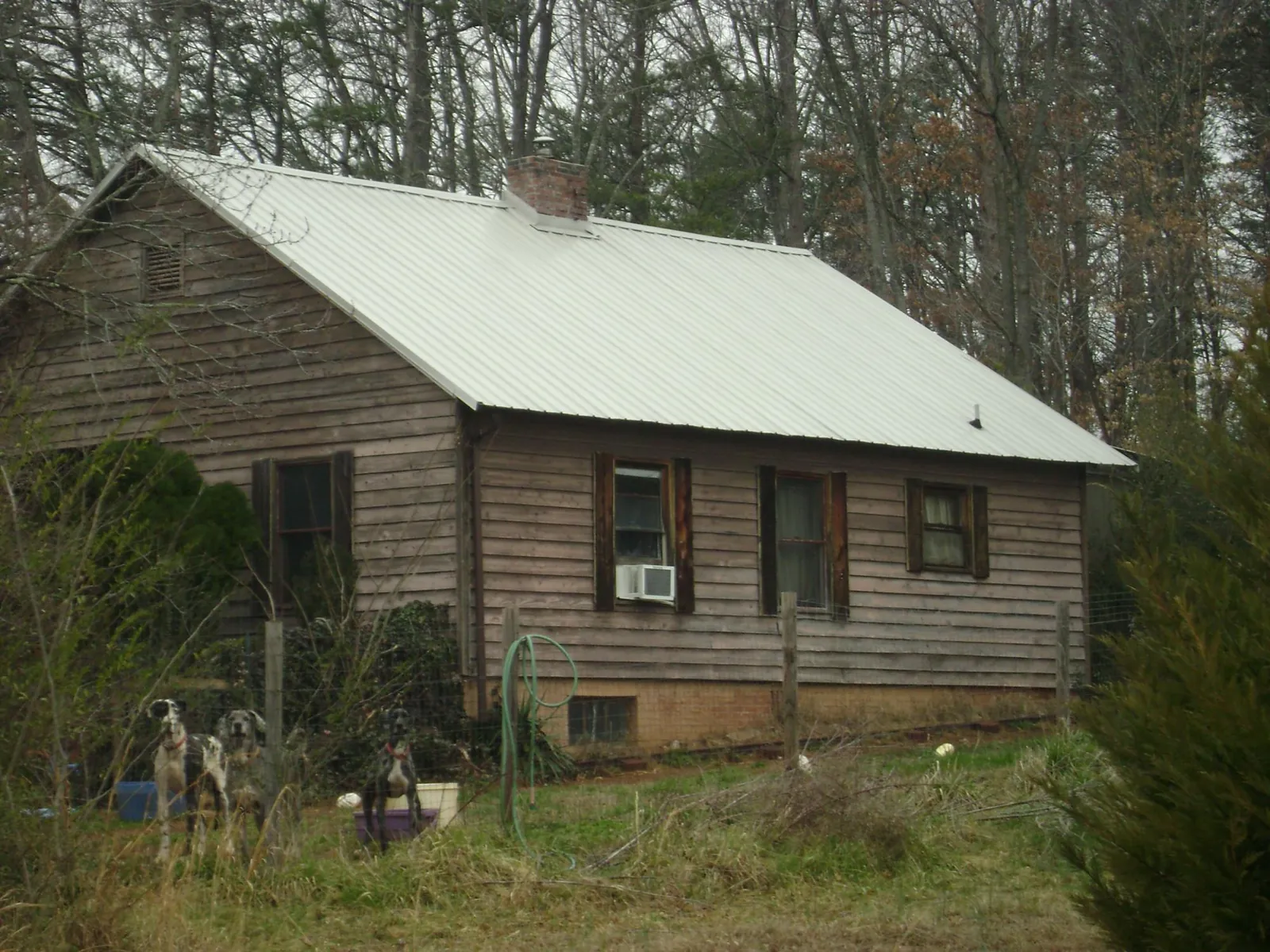 White metal roof on an old wood sided farmhouse, from a Metal Roof Installation job in Edwards